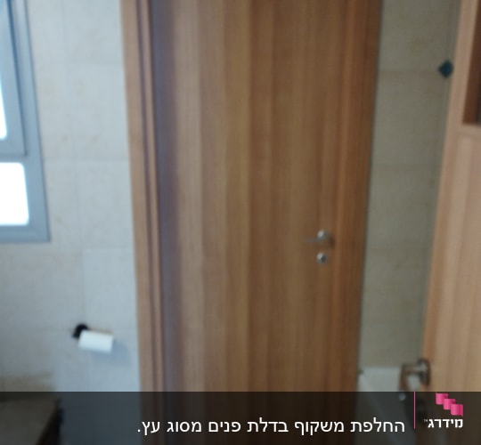 דלת עץ חומה עם ידית מתכת בחדר אמבטיה